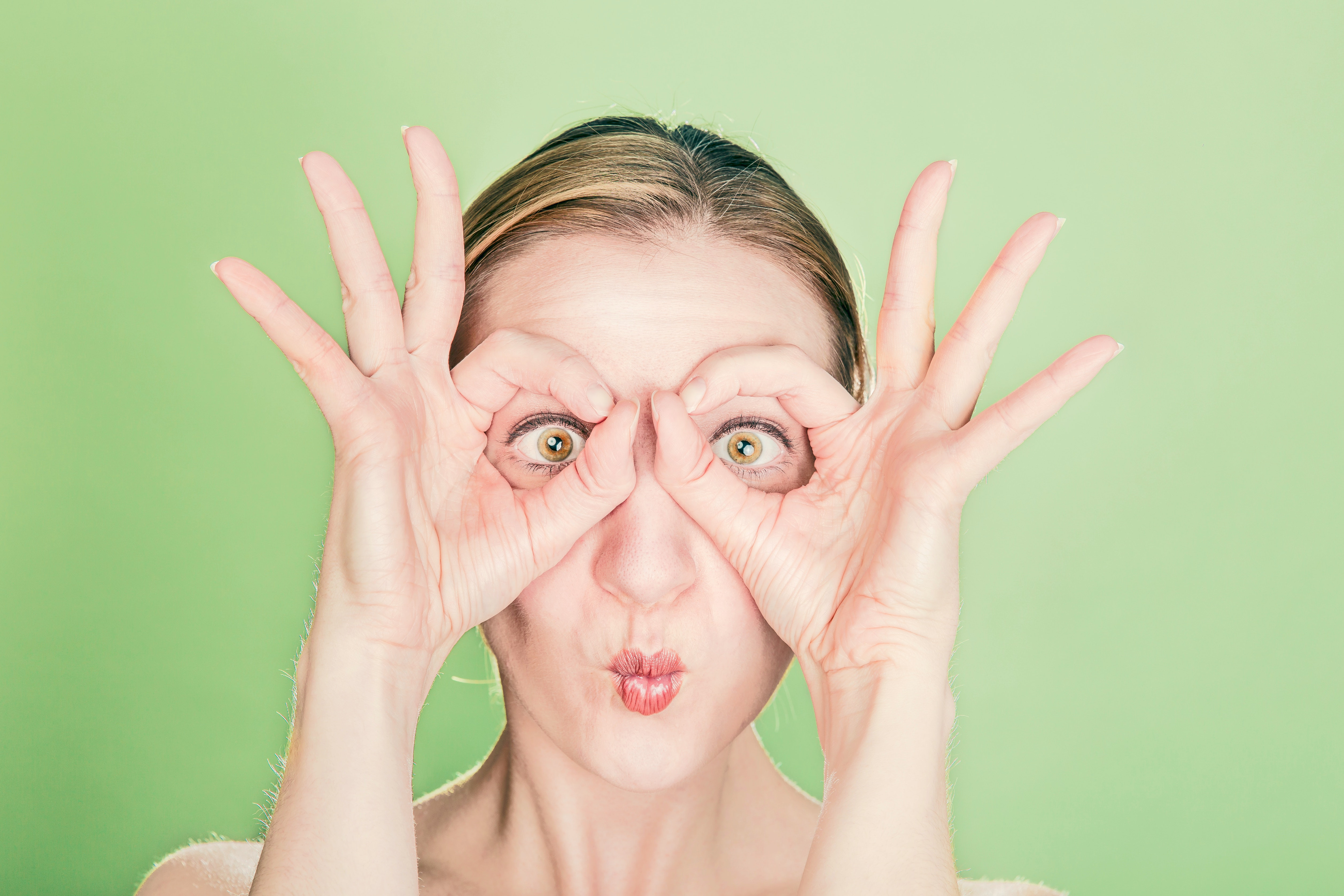 image of a woman with her fingers around her eyes to make pretend glasses