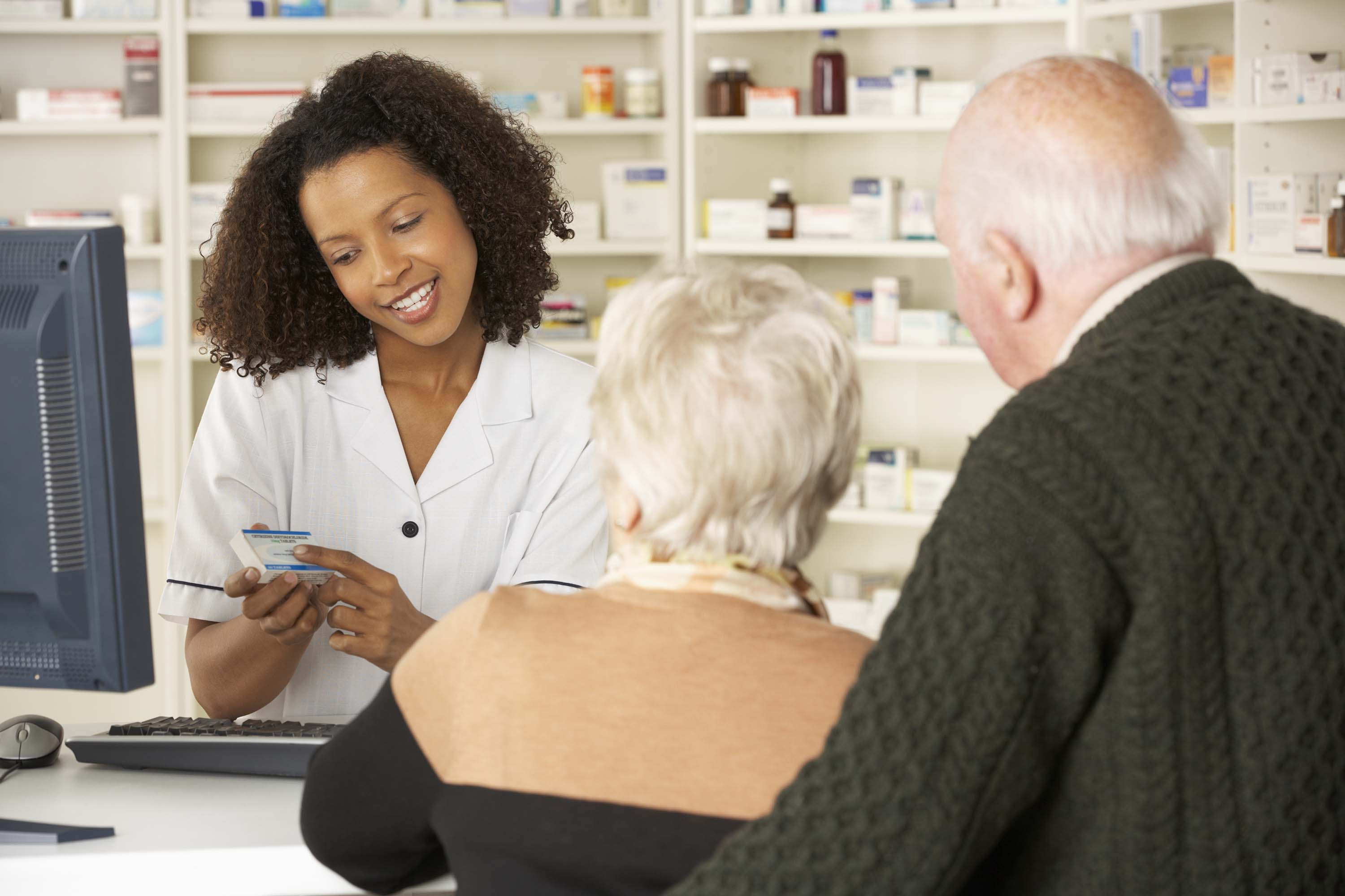 image of a pharmacist explaining the information on the prescription to a couple