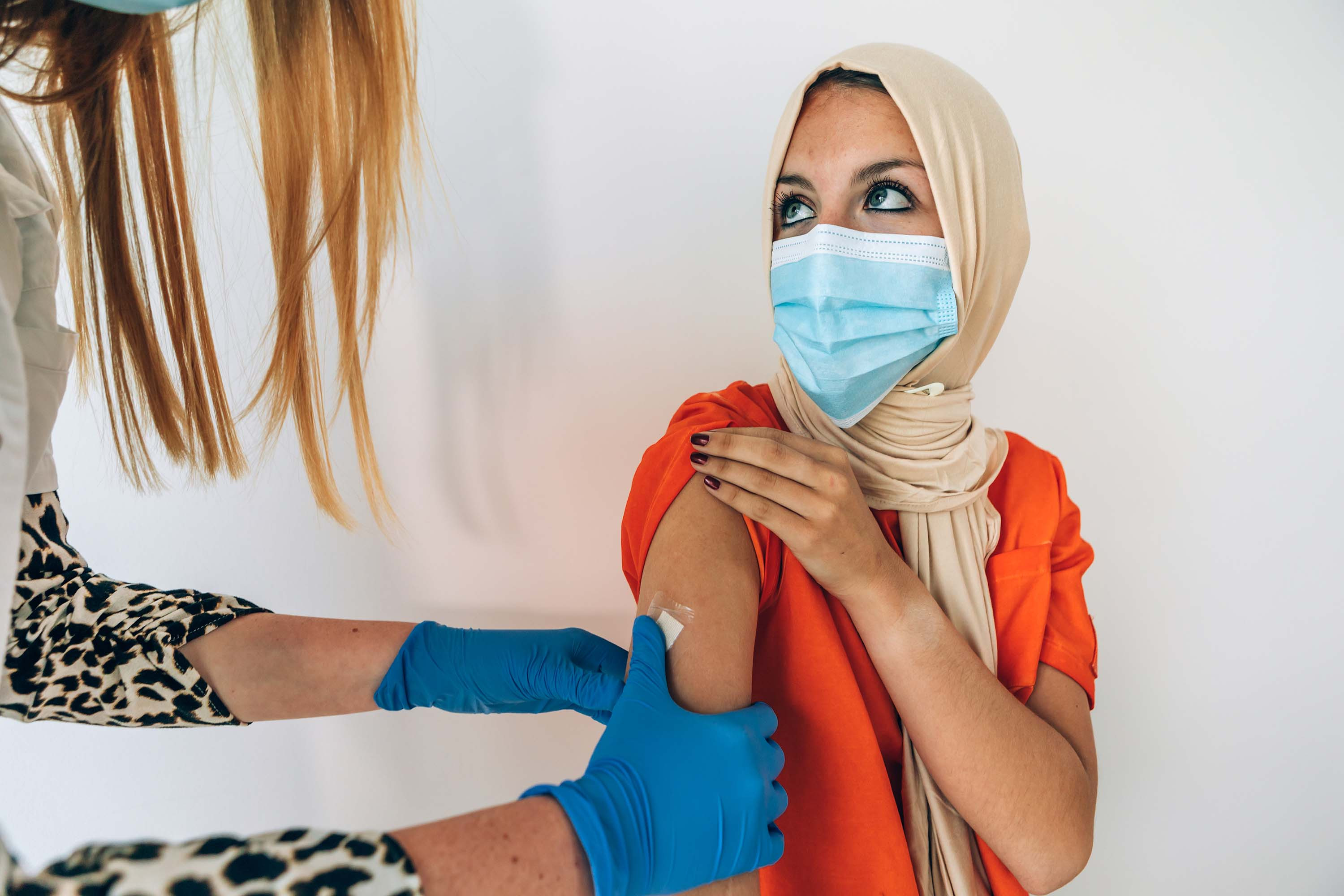  Image of a medical professional vaccinating a woman